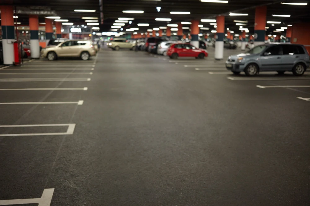 Beton tavan ve kolonlarla çevrili kapalı otoparkta park edilmiş araçlar